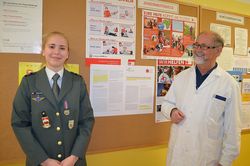 OStR Galler mit Valentina Koller vor der Anschlagtafel des Jugendrotkreuzes